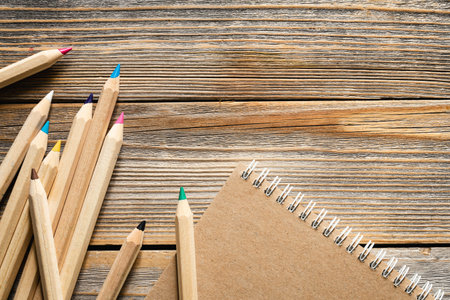 Wooden pencils and recycled notebook on a wooden background, flat lay.の写真素材