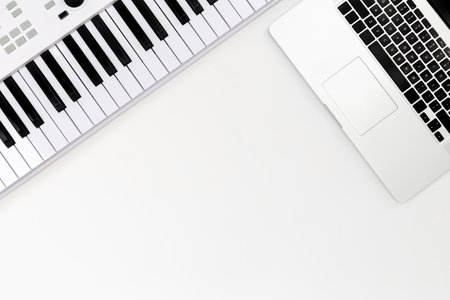 Musical keys and a laptop on a white background, top view, minimalism.