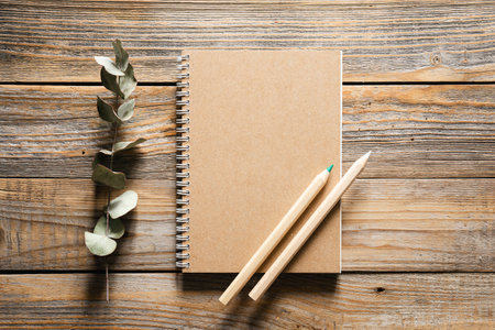 Wooden eco pencils and recycled notebook on a wooden background, top view.の写真素材