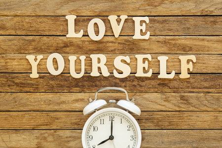 The inscription Love yourself made of wooden letters on a wooden background.の写真素材