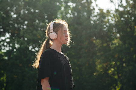A teenage girl listens to music while training at the stadium.