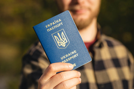 New Ukrainian blue biometric passport with identification chip in hands.の写真素材