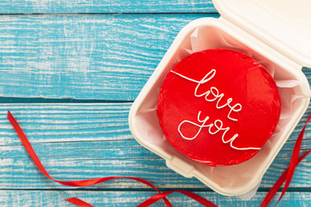 Red bento cake with I love you inscription on a wooden background, top view.の写真素材