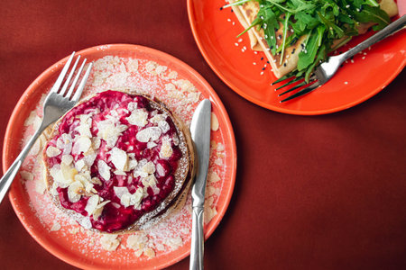 Pancakes with raspberries and a thin pancake stuffed with meat with arugula.の写真素材