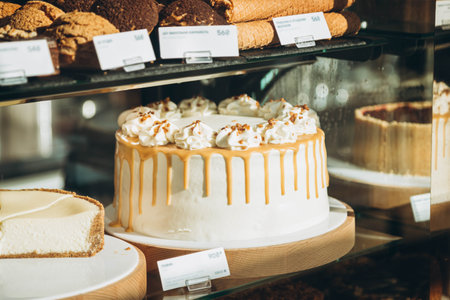 Toffee cake with caramel topping, cream cheese and banana on display in a cafe.