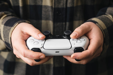 A man plays a video game, a gamepad in the hands of a man close-up.の写真素材