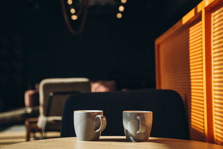 Two gray cups in the interior of a sunny cafe in the morning.の写真素材