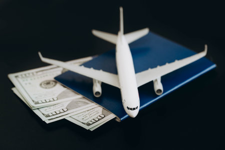 Passport, money and airplane on a black background, close up.の写真素材
