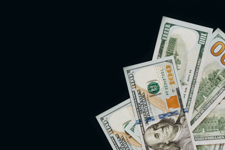 Many dollar banknotes on black background isolated, flat lay.