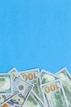 Many dollar banknotes on blue background isolated, flat lay.の写真素材