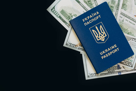 Biometric Ukrainian passport and money on a black background, copy space.の写真素材