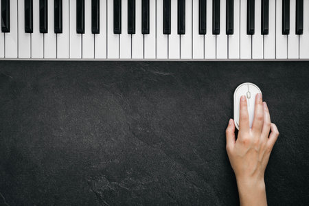 Music background with piano and computer mouse in female hand, flat lay.
