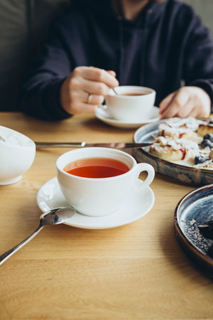A man drinks tea in a cafe during breakfast, the concept of a sweet breakfast.の写真素材