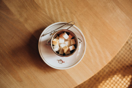 Brown and white sugar cubes in a bowl on a wooden table. Top view.の写真素材