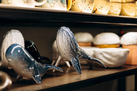 Ceramic whale figures and handmade tableware on a store shelf.の写真素材