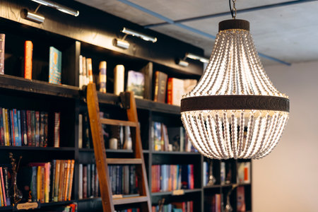 Vintage chandelier in an old bookstore with a wooden ladder in the background.の写真素材