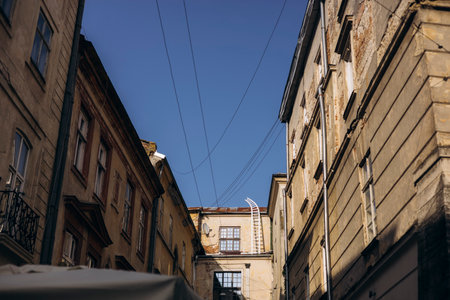 Narrow old European street with buildings and blue sky, charming travel scene.の写真素材