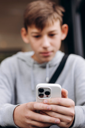 Close-up of teen boy holding smartphone concept of gadget addiction.の写真素材