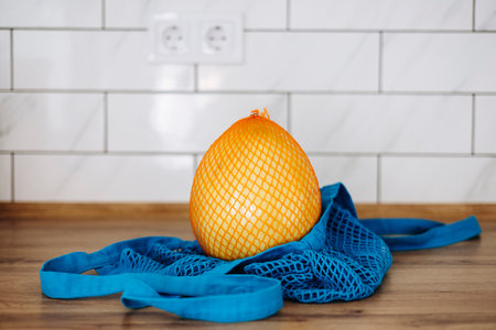 Pomelo in eco bag on kitchen counter, sustainable lifestyle concept, copy space.の写真素材