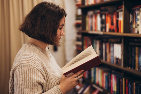 Young student woman browsing bookshelves in a bookstore.