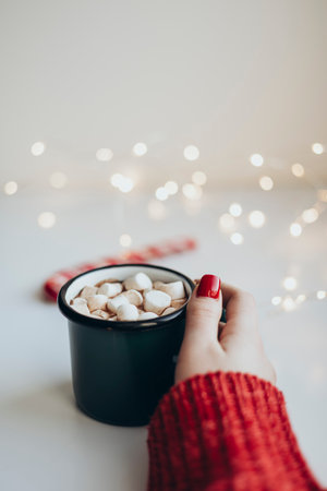 Womans hands holding cup of Hot Chocolate with marshmallows at Christmas time.の写真素材