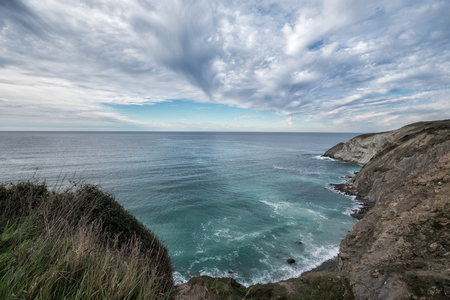 sea cave framing a beautiful beach at sunriseの写真素材