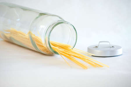 Spaghetti spilling out of a glass jarの写真素材