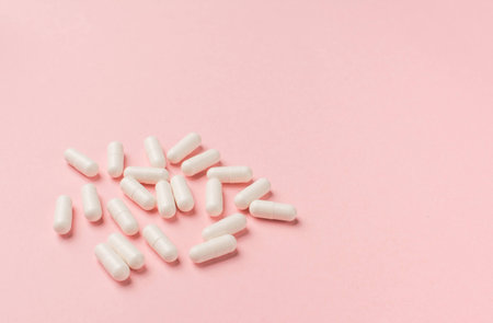 Illness concept: tablets on a pink background close upの写真素材