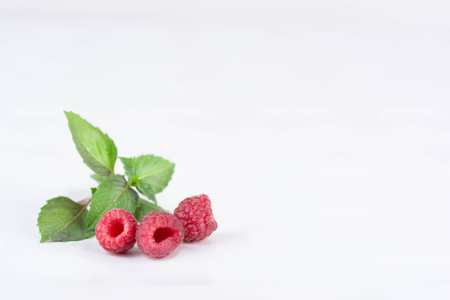 Fresh ripe raspberries on a white background. Close-up, minimal concept of fashion foodの写真素材