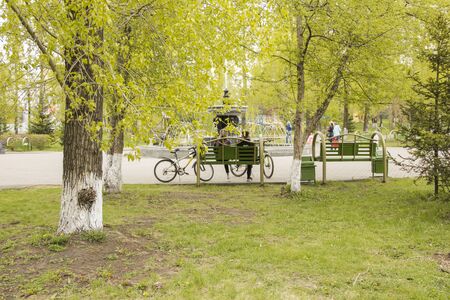 the guy with the girl is sitting in front of the fountain. People relax on the bench. Young people sit on a bench, bicycles stand nearby.の写真素材
