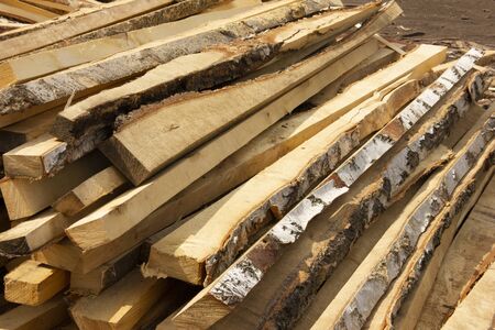sawing trees into small bars. processing of trees at a sawmill. logging for the winter.の写真素材