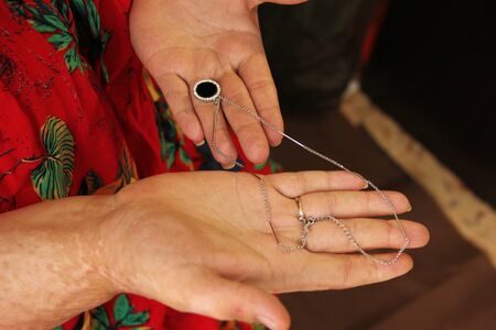 Overweight woman holding jewelry in her hands. On her hands are scars from burns. Plus size model.