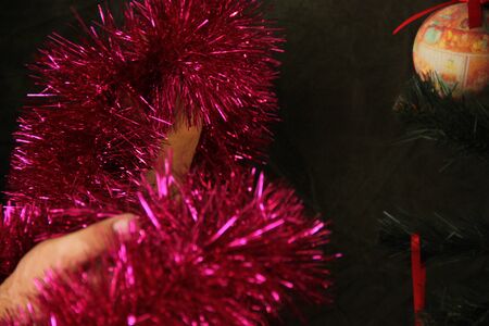 Fat woman decorates a Christmas tree. Joy of the upcoming holiday. Tree Decor.の写真素材
