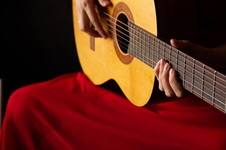 female hands hold an acoustic guitar. play music.