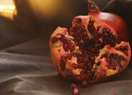 Open grenade lies against a black background. red grains glisten. dark-key macro photographyの写真素材
