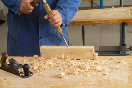 Grey man works chime on wood. carpenters job. Hobby at 60の写真素材