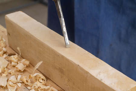 Grey man works chime on wood. carpenters job. Hobby at 60