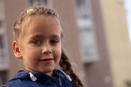 portrait of a beautiful girl of 5 years in the background of the house