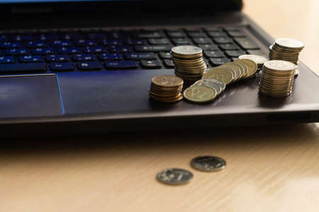 metal coins lie on the laptops keyboard