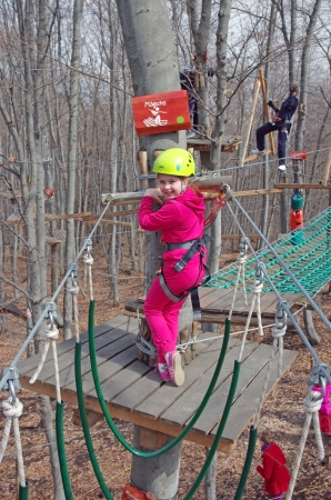 MAGURA, ROMANIA - APRIL 05: Little girl smiling in adventure park. Magura Green Park on April 05, 2013 in Magura, Romaniaのeditorial素材