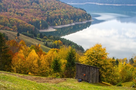Alpine hut with lake behind in autumn.の写真素材