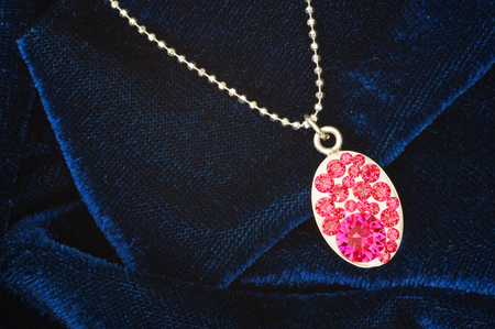 Pink stones on pendant over blue velvetの写真素材