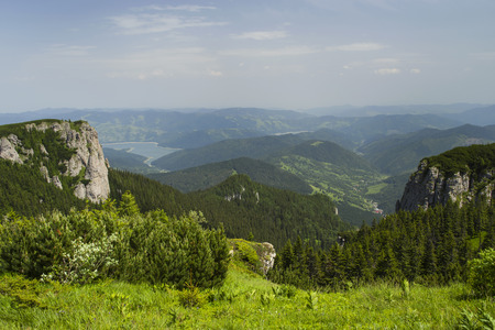 Summer landscape from the top of mountains, green pasture and forest in valley.の写真素材
