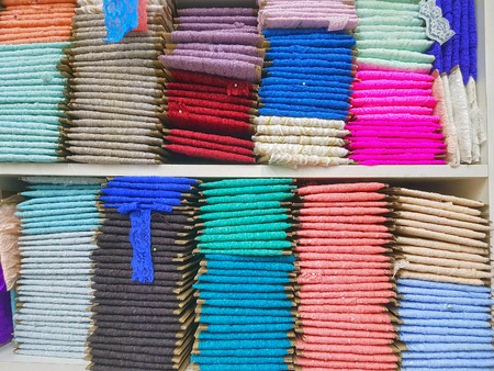 Traditional lace fabrics for sale, in the market, stack of colorful lace fabricsの写真素材