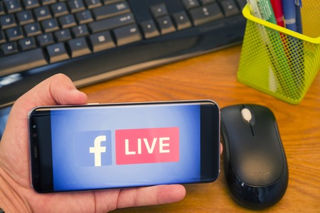 PIATRA NEAMT, ROMANIA - JULY 30, 2018: Hand holds a Samsung S8+ with Facebook Live logo on the...