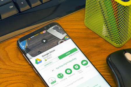PIATRA NEAMT, ROMANIA - JULY 30, 2018: Samsung S8+ with Google Play store, Google Drive  application, office background.のeditorial素材