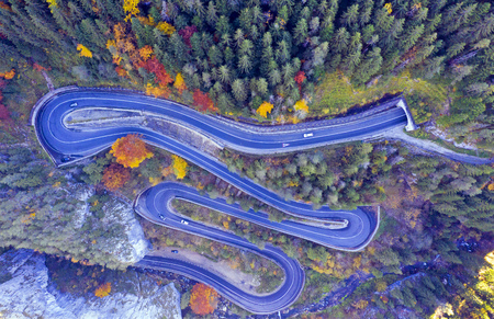 Above view of a curvy road through autumn forest in a canyon. Bicaz gorge is a narrow pass between...