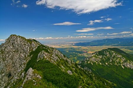 Summer landscape from the top: rocky mountain crest and beautiful valley.Romanian Carpathiansの写真素材