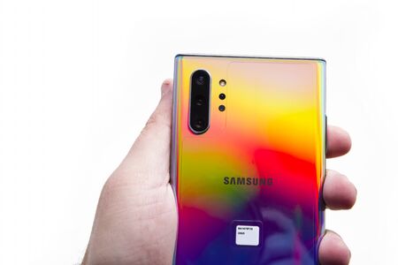 PIATRA NEAMT, ROMANIA - NOVEMBER 22, 2019: Hand holding Samsung Note 10 with triple camera and colored back sideのeditorial素材