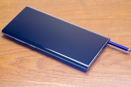 PIATRA NEAMT, ROMANIA - NOVEMBER 25, 2019: Stylus and Samsung Galaxy Note 10 on the deskのeditorial素材